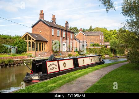 Canal narrowboat moored alongside canal side cottages on the Trent and Mersey canal at Anderton near Northwich in Cheshire Stock Photo