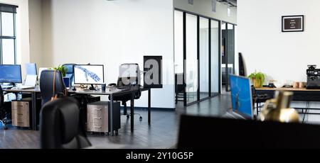 Modern office with multiple workstations and computers, featuring robotic arm Stock Photo