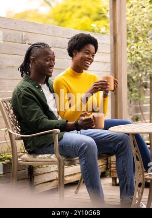 Smiling African American couple sitting on patio, enjoying coffee and spending quality time together Stock Photo