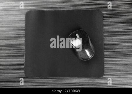 Computer mouse with mousepad on black wooden table, top view Stock Photo