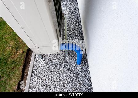 Two efficient outdoor heat pump units placed in front of the house. Stock Photo