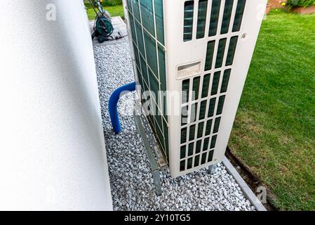 Two efficient outdoor heat pump units placed in front of the house. Stock Photo