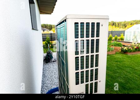 Two efficient outdoor heat pump units placed in front of the house. Stock Photo