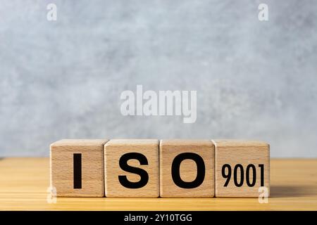 ISO 9001 certified concept. ISO text on wooden cubes. Gray background. Quality control. Stock Photo