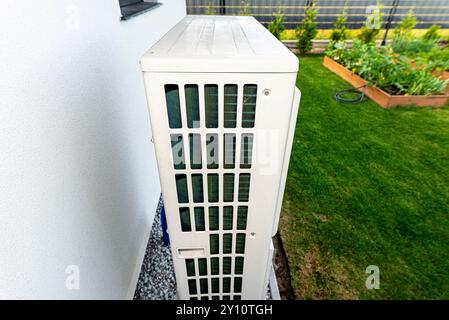 Two efficient outdoor heat pump units placed in front of the house. Stock Photo