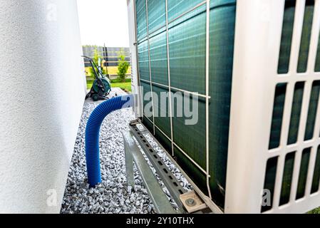 Two efficient outdoor heat pump units placed in front of the house. Stock Photo