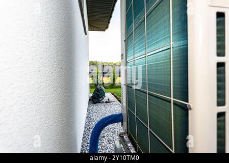 Two efficient outdoor heat pump units placed in front of the house. Stock Photo
