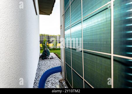 Two efficient outdoor heat pump units placed in front of the house. Stock Photo