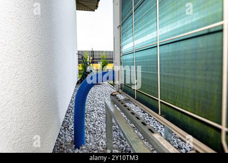 Two efficient outdoor heat pump units placed in front of the house. Stock Photo