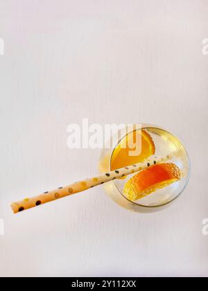 A non-alcoholic soft drink with a straw and orange slices in mineral water in a glass, refreshment in summer Stock Photo