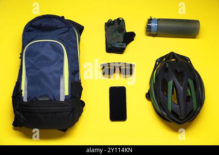 Flat lay composition with cycling accessories and smartphone on yellow background Stock Photo