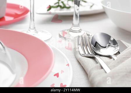 Table setting for romantic Valentine's day celebration. Plates, cutlery and hearts Stock Photo