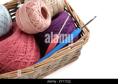 Many colorful yarns and crochet hooks in wicker basket isolated on white Stock Photo