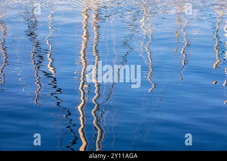 the masts of the boats moored in the marina reflected in the slightly moving water. Porto Vecchio, Corse-du-Sud, Corsica, France Stock Photo