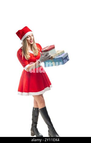 Young blonde Santa Claus walking balancing several gift boxes isolated on white background Stock Photo