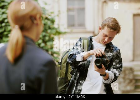 Young Photographer Adjusting Camera in Outdoor Setting Stock Photo