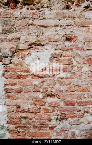 Weathered Brick Wall with Cracked and Peeling Plaster Stock Photo