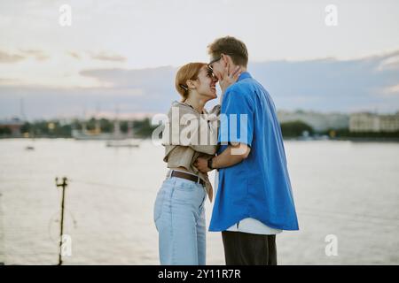 Couple Embracing by Waterfront During Sunset Stock Photo