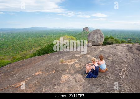 Sigiriya, Sri Lanka; September 4, 2024 - A couple of people enjoy a distant view of Sigiriya Rock in Sri Lanka from the top of Pidurangala rock. Stock Photo