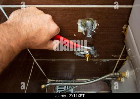 Plumber removing the faucet in the toilet in close-up Stock Photo