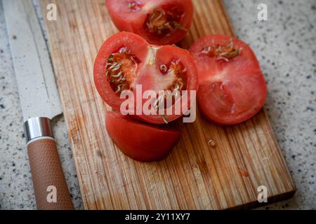 Vivipary seeds germinating inside overripe tomato on the cutting desk Stock Photo