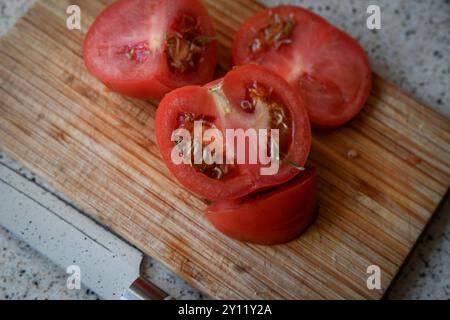 Vivipary seeds germinating inside overripe tomato on the cutting desk Stock Photo