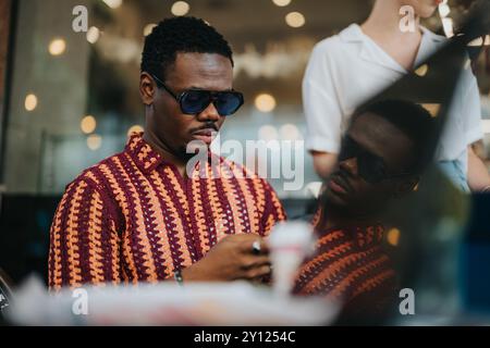 Businessman wearing sunglasses using smart phone in modern coffee shop Stock Photo