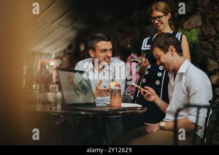 Young professionals collaborating in a casual outdoor cafe meeting Stock Photo