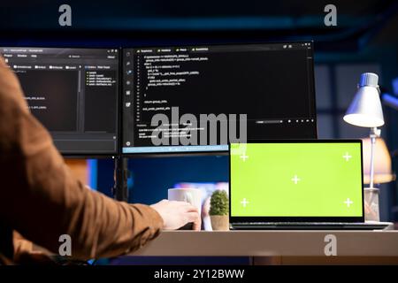 Admin using green screen laptop to filter malicious traffic from cybercriminals attempting to corrupt company data. IT expert working on chroma key notebook, preventing malware and phishing attacks Stock Photo