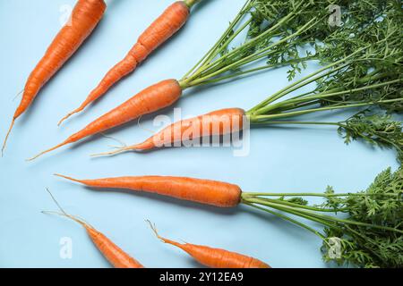 Fresh carrots with leaves on blue background Stock Photo
