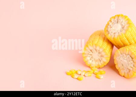 Cut fresh corn cobs and seeds on pink background Stock Photo