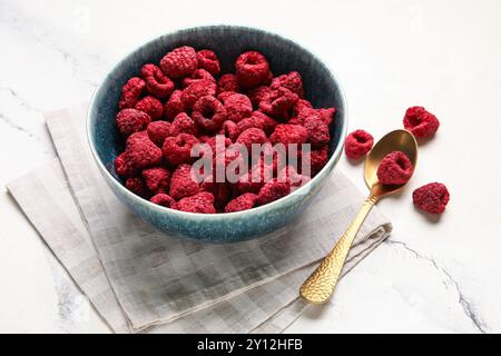 Bowl of dehydrated raspberries on white background Stock Photo