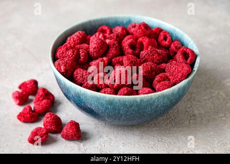 Bowl of dehydrated raspberries on grey background Stock Photo