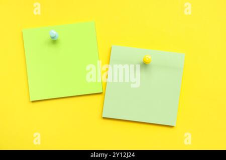 Paper notes pinned on yellow background Stock Photo