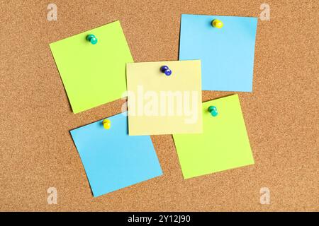 Different blank sticky notes on cork board as background Stock Photo