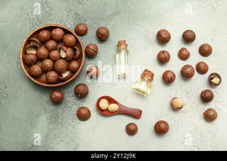 Bottles of macadamia oil and nuts on grunge background Stock Photo