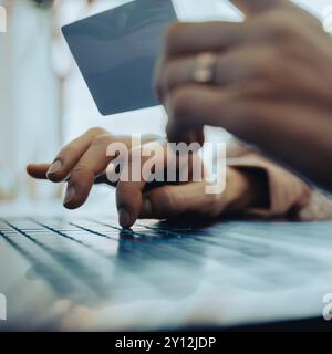 Closeup low angle view of female hands using laptop computer and holding a credit card while online shopping or banking. Stock Photo