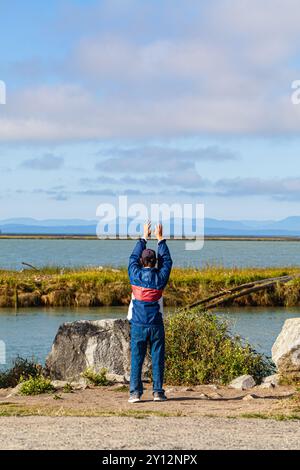 Asian man performing his morning routine at Gary Point Park in Steveston Canada Stock Photo
