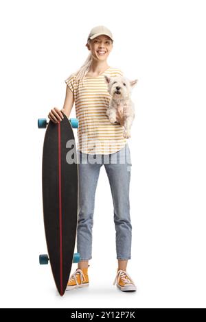Young female posing with a longboard and dog in her hands isolated on white background Stock Photo