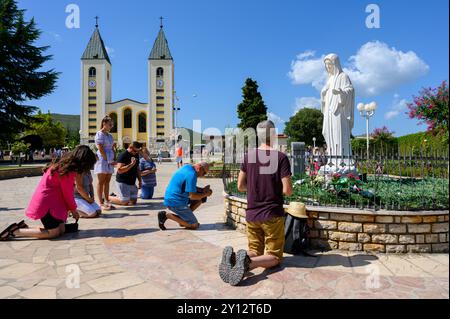 People praying around the statue of the Queen of Peace near the St James Church in Medjugorje, Bosnia and Herzegovina. Stock Photo