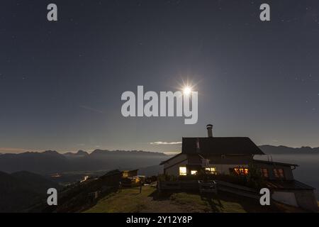 Mountain hut at full moon in front of mountains, at night, illuminated, Wankhaus, view of Karwendel mountains, Bavaria, Germany, Europe Stock Photo