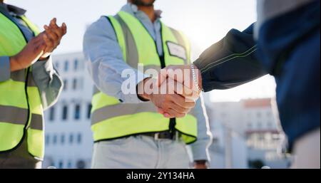 Business people, handshake and meeting with architect for construction deal, b2b or teamwork in city. Closeup, employees or civil engineer shaking Stock Photo