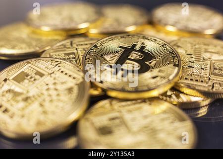 Stack of bitcoins lying on shiny dark surface Stock Photo