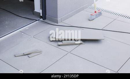 Tiler worling by laying new tiles on a house entrance Stock Photo