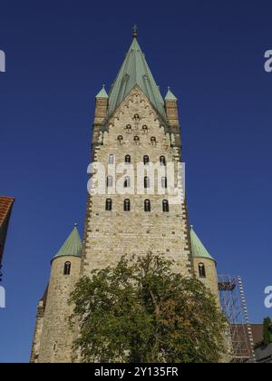 High church tower in Gothic style, rises into the clear blue sky. Historic brick architecture, Paderborn, North Rhine-Westphalia, Germany, Europe Stock Photo