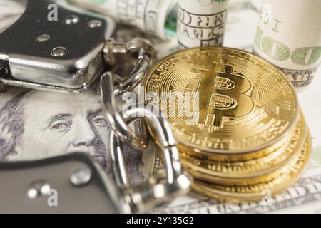 Golden Bitcoins Cryptocurrency with Handcuffs on Dollar bills. Digital crime, arrest or hacking concept Stock Photo