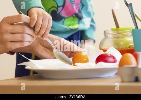 Mother and child painting eggs for Easter holidays Stock Photo