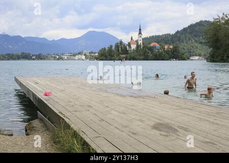 SLOVENIA, BLED, JULY 15, 2019: Outdoor swimming and bathing. Beautiful mountain lake in summer with small Church on island with alps Stock Photo