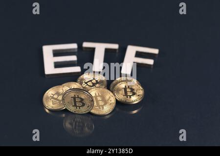 Bitcoin coins with ETF text put on dark background, Concept of the approval of Exchange Traded Fund Stock Photo