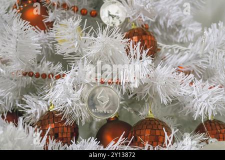 Closeup of Ethereum and christmas, new year gold Ethereum. Crypto currency ethereum on a Christmas tree with red buld Stock Photo